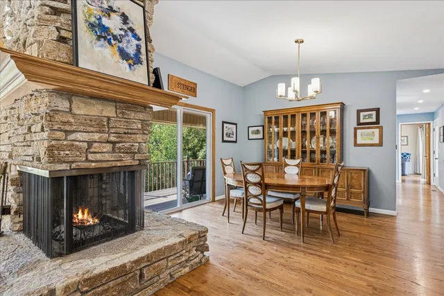 a dining room with furniture a fireplace and wooden floor