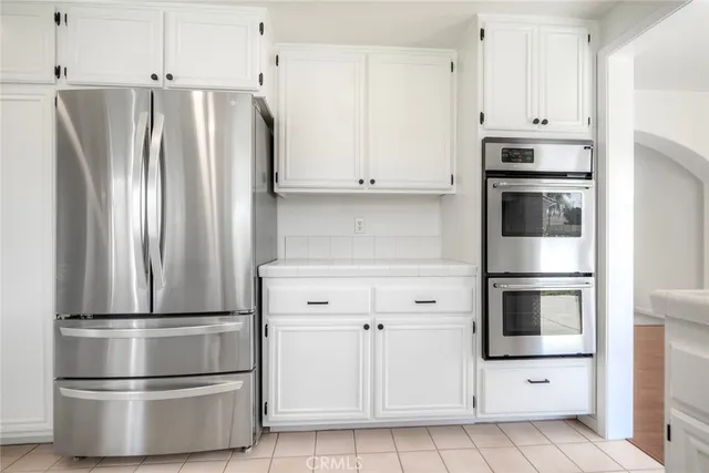 a kitchen with stainless steel appliances white cabinets and a refrigerator