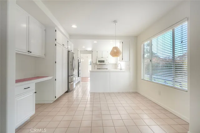 a view of a kitchen with white cabinets and refrigerator