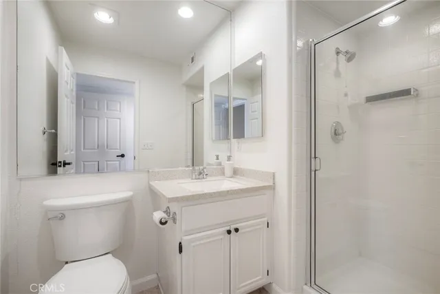 a bathroom with a toilet sink vanity and mirror