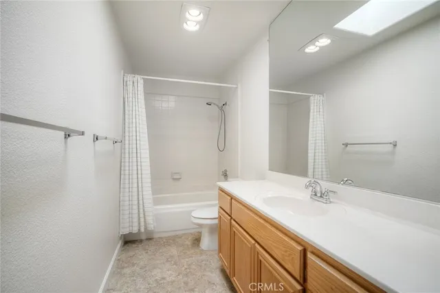 a bathroom with a granite countertop sink a toilet and shower