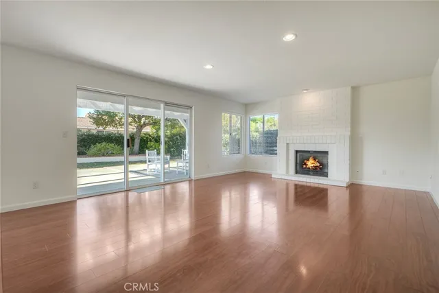 a view of empty room with wooden floor and fireplace