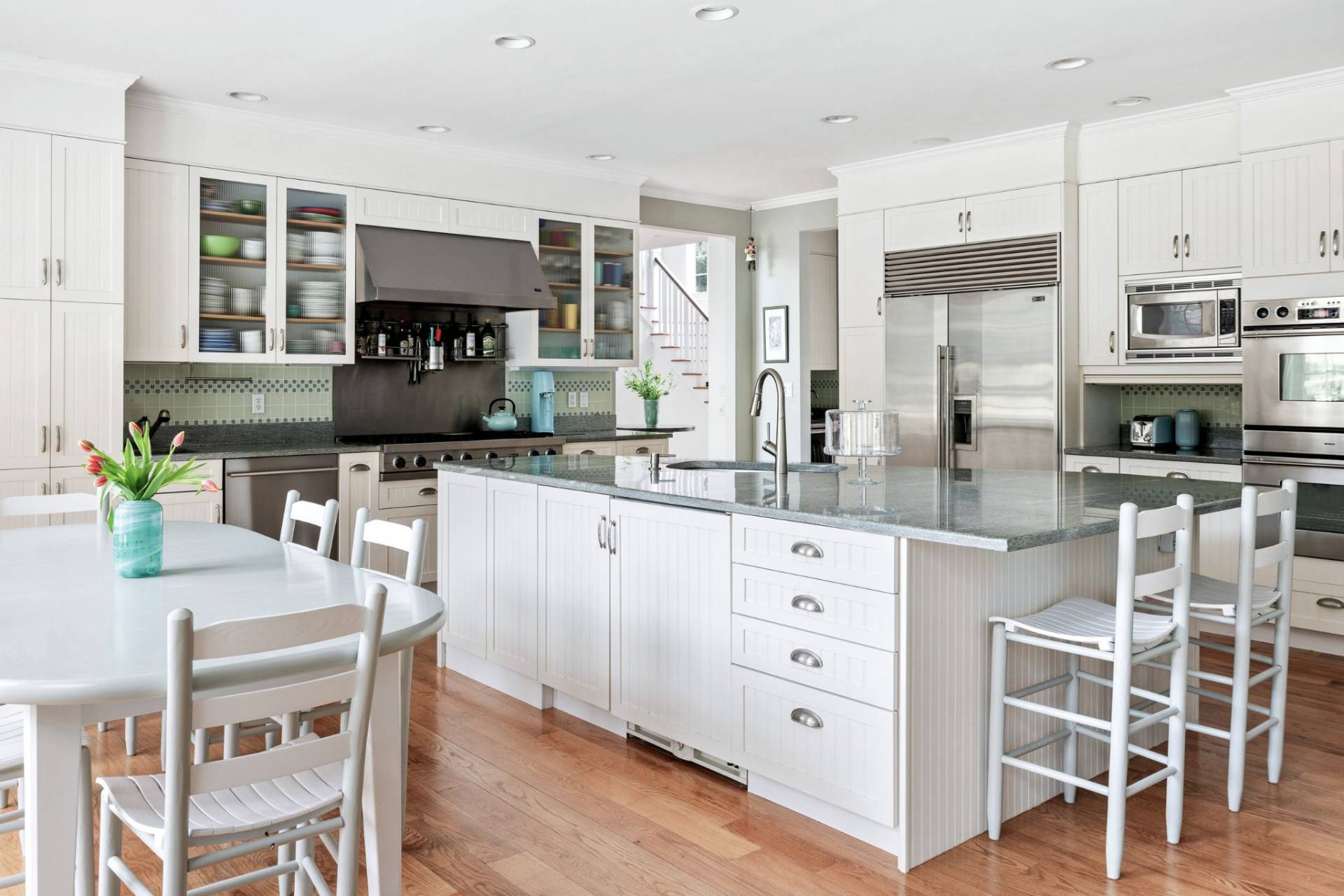 99 Flying Point Road Southampton, NY 11968 - Photo 10 of 20 a kitchen with stainless steel appliances kitchen island granite countertop a table chairs sink and cabinets