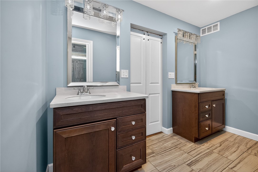 4747 Fawnwood Road Dayton, OH 45429 - Photo 39 of 58 This bathroom offers dual vanities with elegant lighting and rich cabinetry, complemented by stylish tiled flooring.