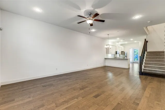 an empty room with wooden floor and fan