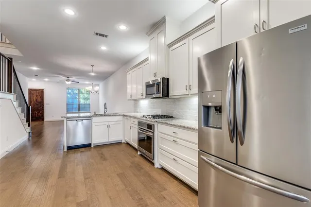 a kitchen with stainless steel appliances a refrigerator sink and stove