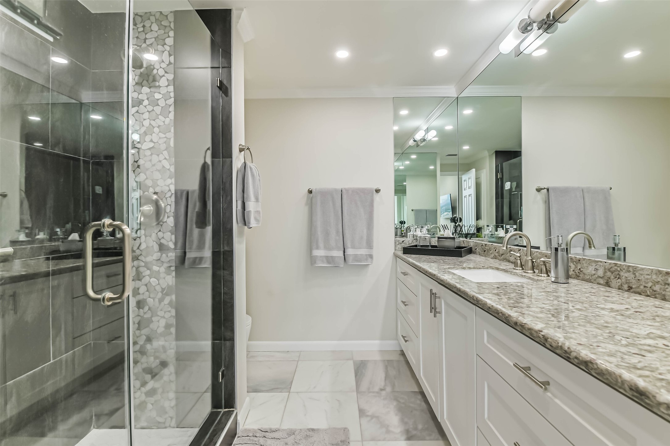 14 Greenway Plaza, Unit 15P Houston, TX 77046 - Photo 12 of 25 a bathroom with a granite countertop sink a large mirror and a shower