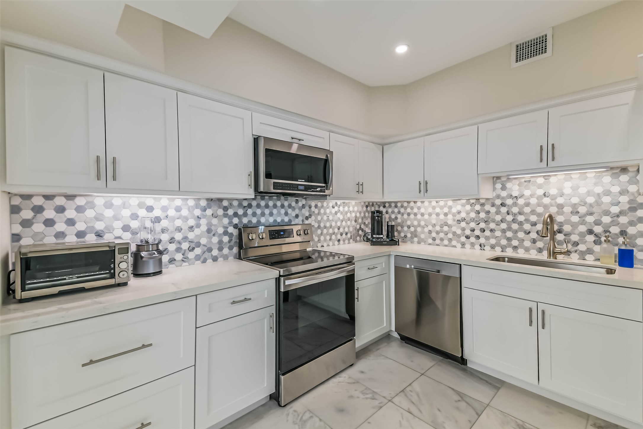 14 Greenway Plaza, Unit 15P Houston, TX 77046 - Photo 7 of 25 a kitchen with white cabinets stainless steel appliances and sink