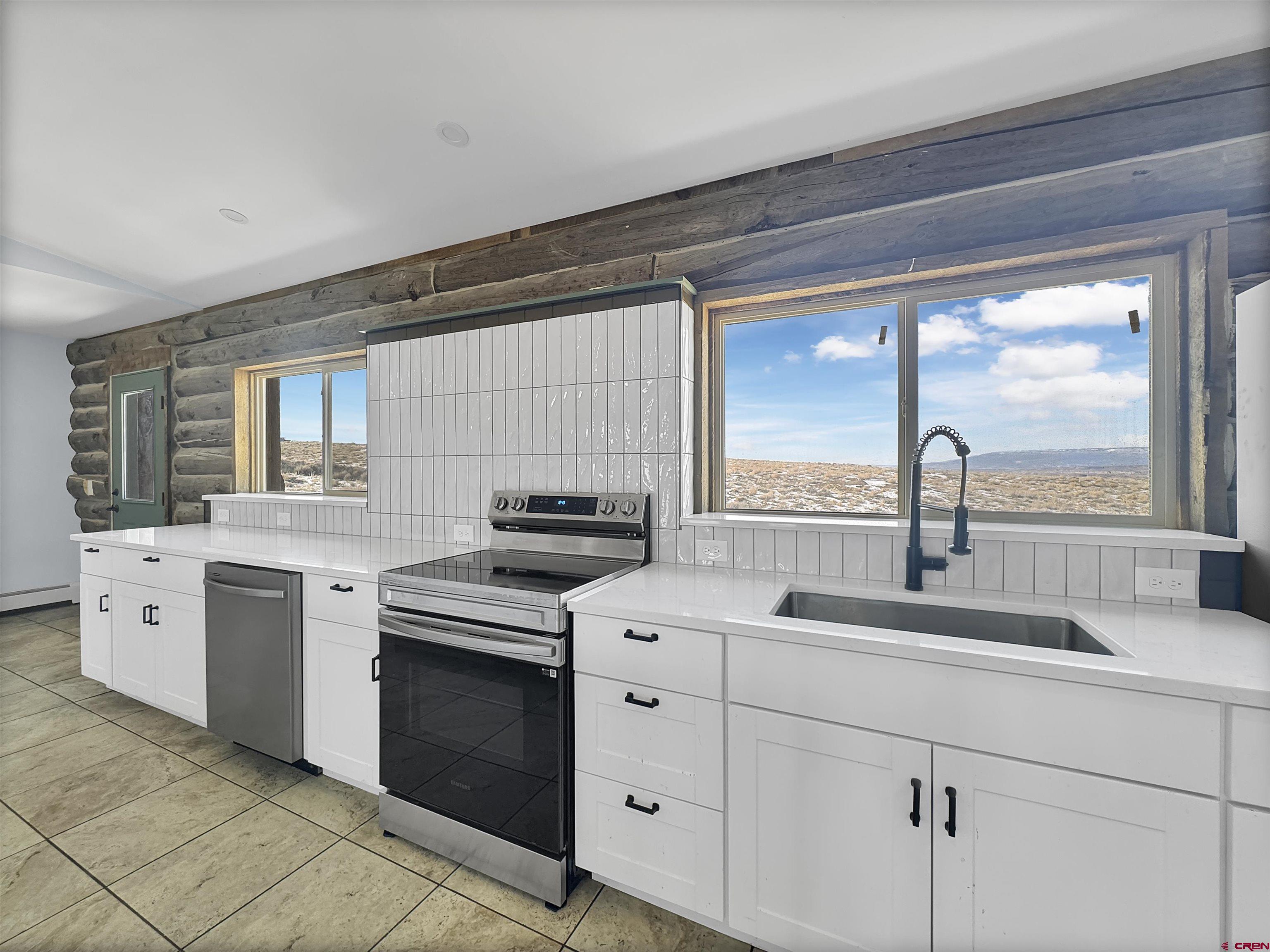 6313 Sagebrush Road Hotchkiss, CO 81419 - Photo 4 of 34 a kitchen with white cabinets and white appliances