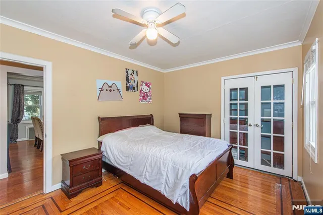 a bedroom with a bed dresser and a wooden floor