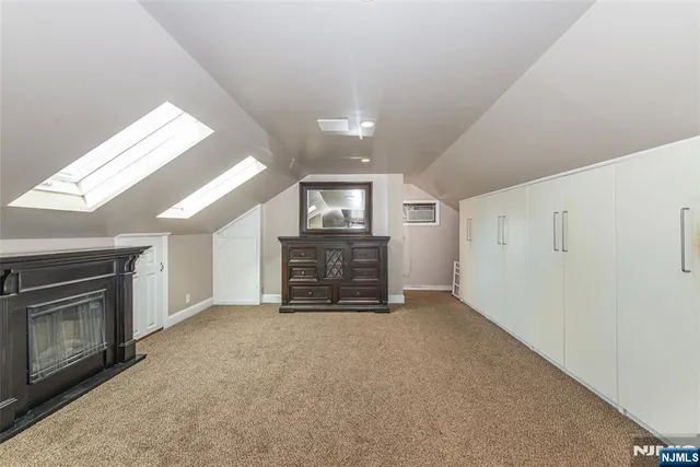 a view of an empty room with a fireplace and a window
