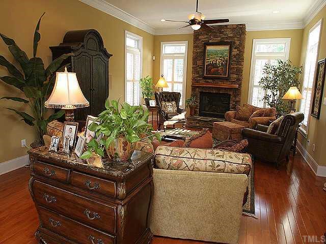 9508 Bluemont Court Raleigh, NC 27617 - Photo 3 of 10 a living room with furniture a fireplace and a flat screen tv