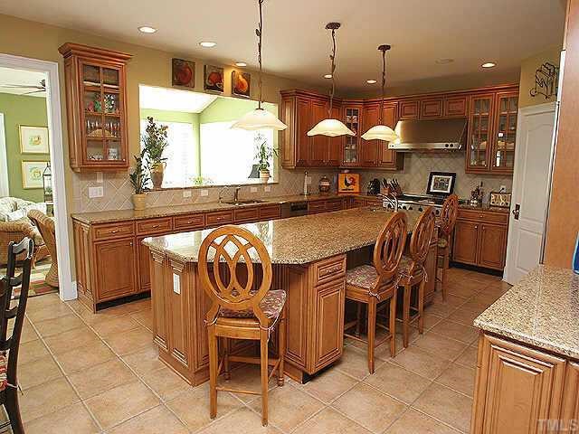 9508 Bluemont Court Raleigh, NC 27617 - Photo 4 of 10 a kitchen with a dining table chairs and white cabinets