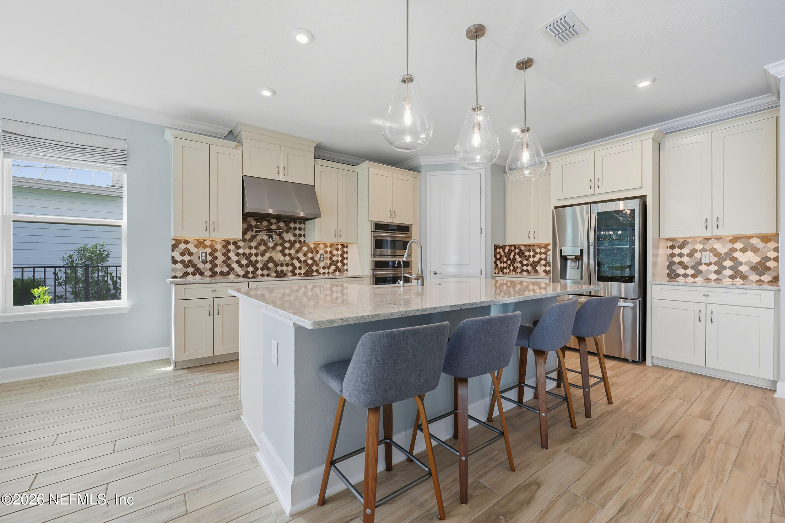 494 Marquesa Circle St. Johns, FL 32259 - Photo 15 of 76 a kitchen with stainless steel appliances kitchen island granite countertop a wooden floor and white cabinets