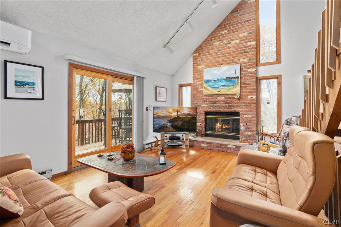 3215 Cherry Ridge Road Bushkill, PA 18324 - Photo 13 of 50 a living room with furniture a fireplace and a floor to ceiling window