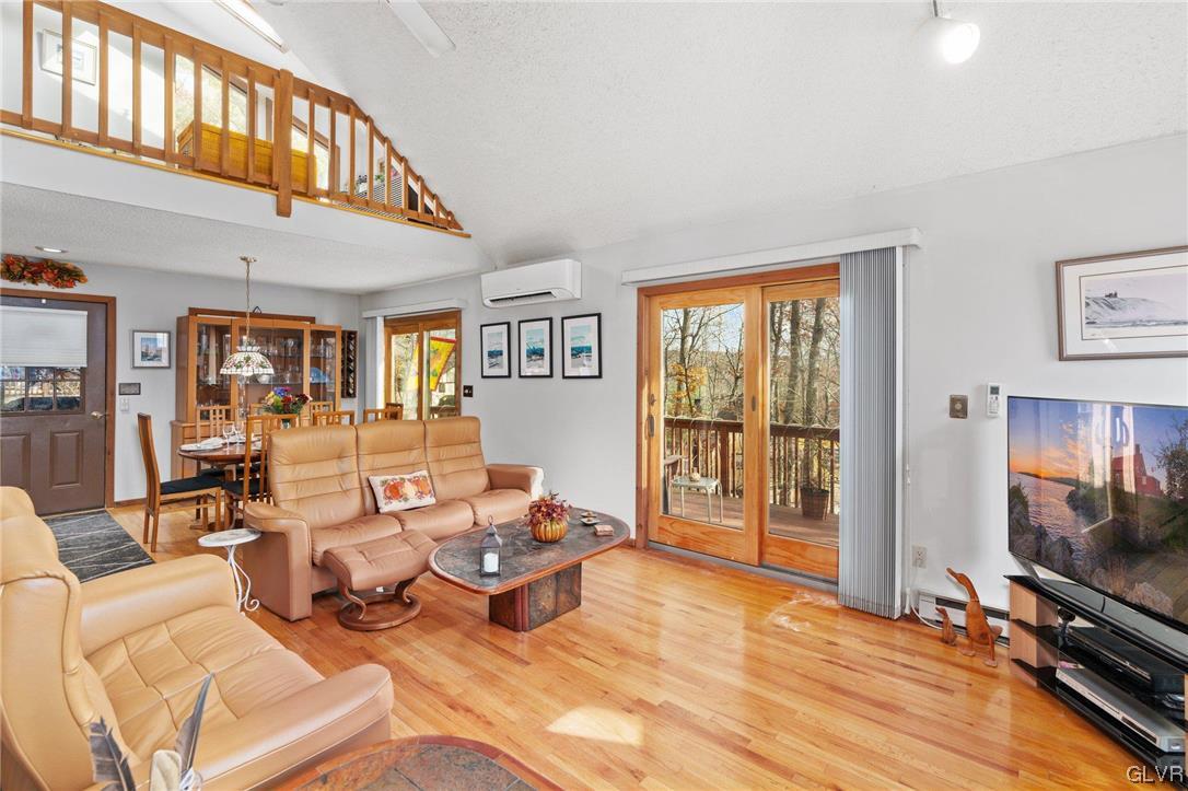 3215 Cherry Ridge Road Bushkill, PA 18324 - Photo 18 of 50 a living room with furniture a flat screen tv and floor to ceiling window
