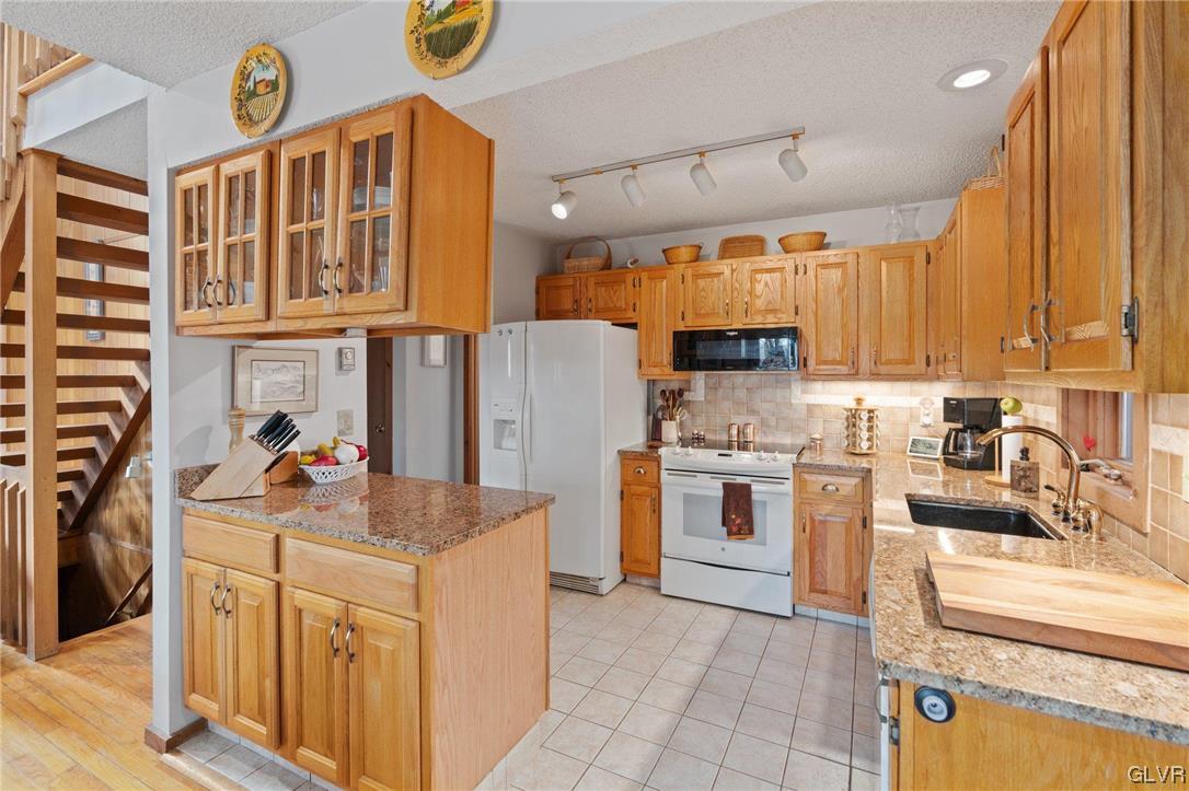3215 Cherry Ridge Road Bushkill, PA 18324 - Photo 24 of 50 a kitchen with stainless steel appliances granite countertop a sink dishwasher stove and refrigerator with wooden cabinets