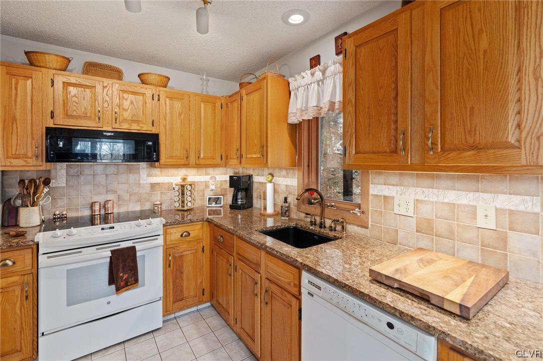 3215 Cherry Ridge Road Bushkill, PA 18324 - Photo 25 of 50 a kitchen with stainless steel appliances granite countertop a sink a stove and cabinets