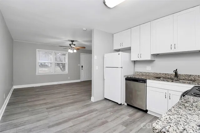 a kitchen with a refrigerator and a stove top oven