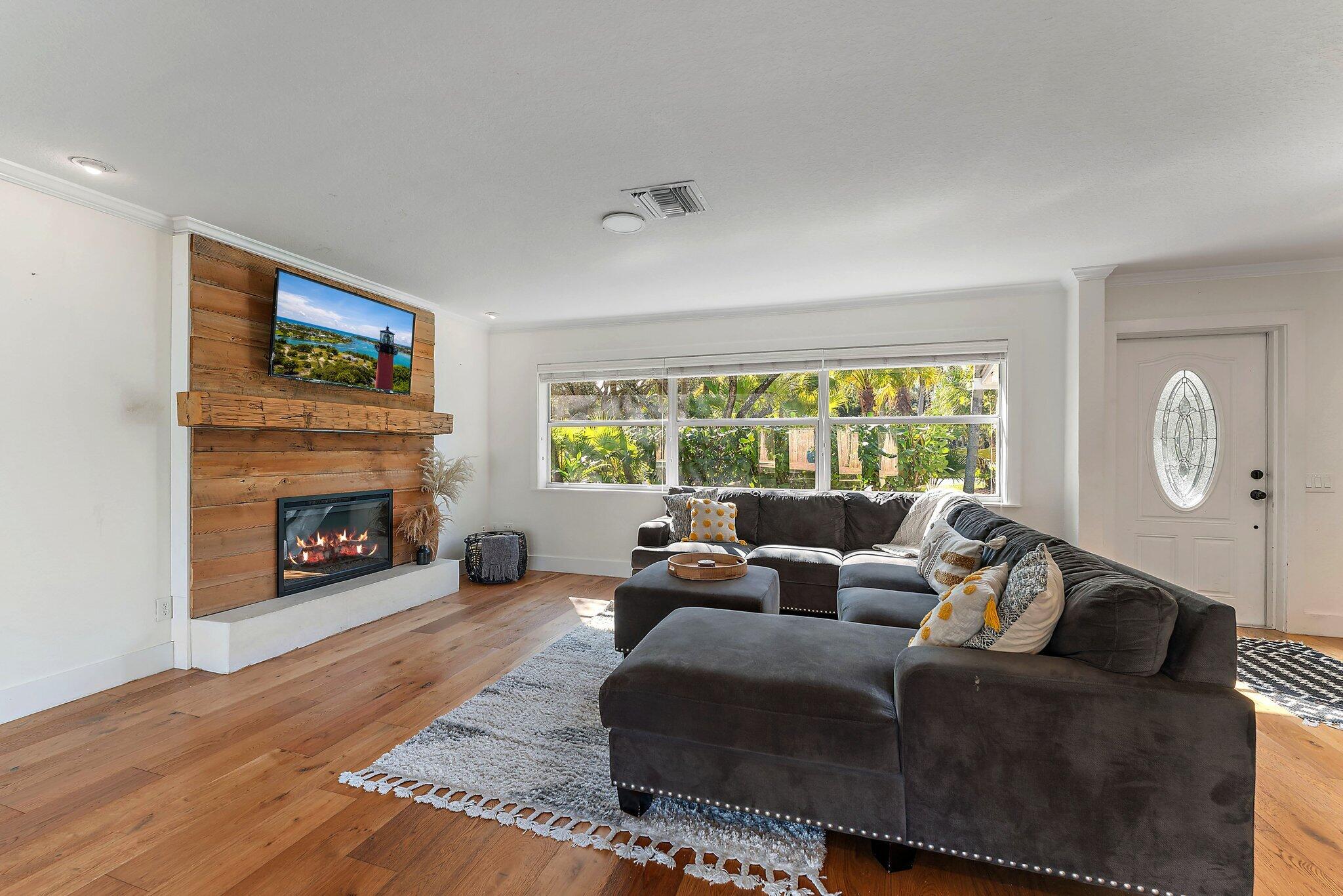 5692 Pennock Point Road Jupiter, FL 33458 - Photo 11 of 51 a living room with furniture a fireplace and a large window