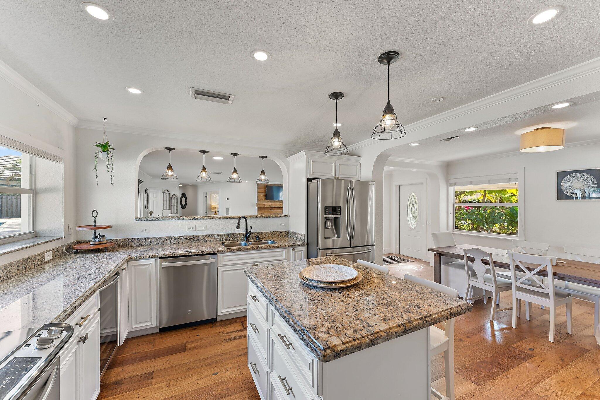 5692 Pennock Point Road Jupiter, FL 33458 - Photo 17 of 51 a kitchen with center island table and chairs in it