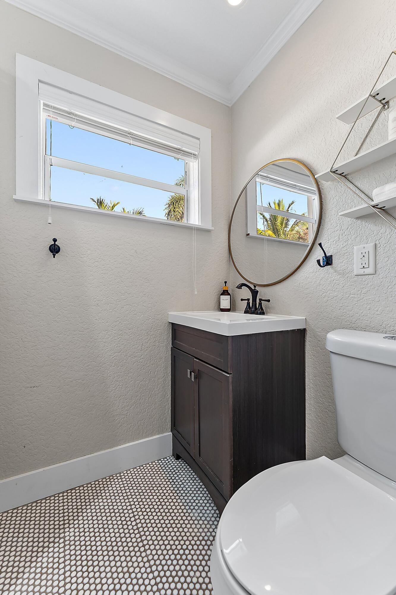 5692 Pennock Point Road Jupiter, FL 33458 - Photo 34 of 51 a bathroom with a toilet a sink and mirror