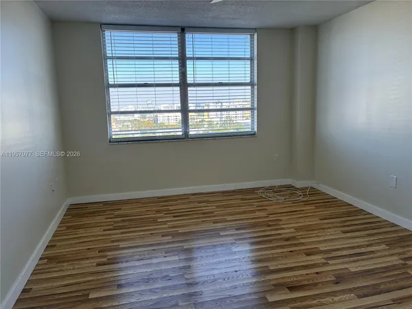 a view of a room with wooden floor and window
