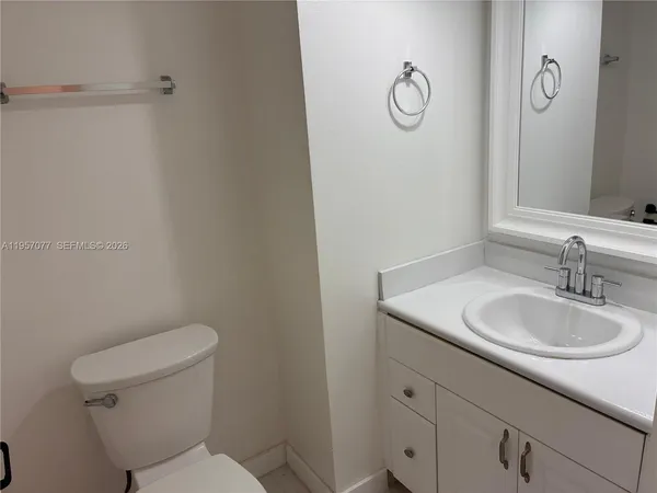a bathroom with a toilet sink vanity granite and mirror