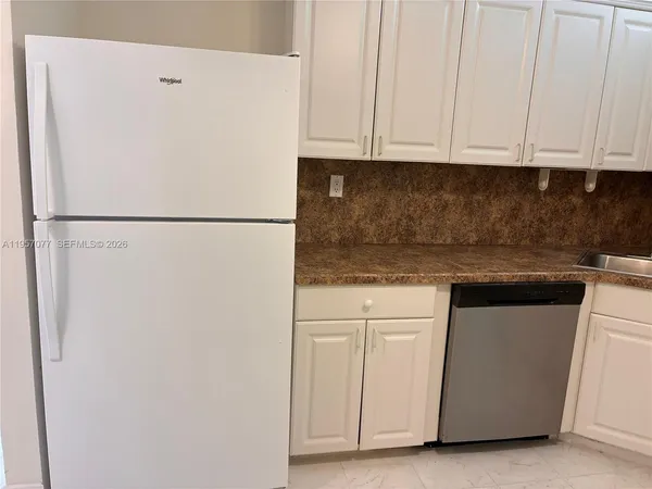 a white refrigerator freezer sitting inside of a kitchen