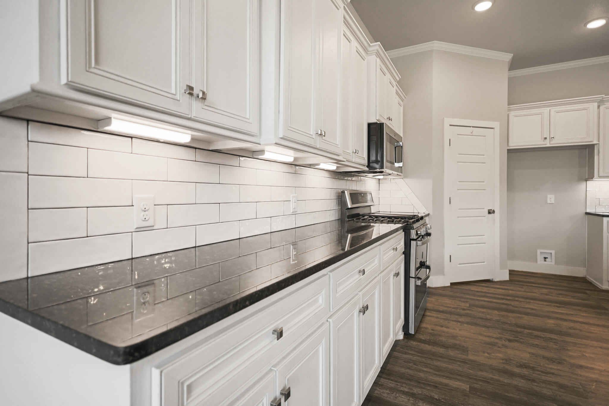 7808 58th Street Lubbock, TX 79407 - Photo 11 of 50 a kitchen with stainless steel appliances granite countertop a sink and a stove