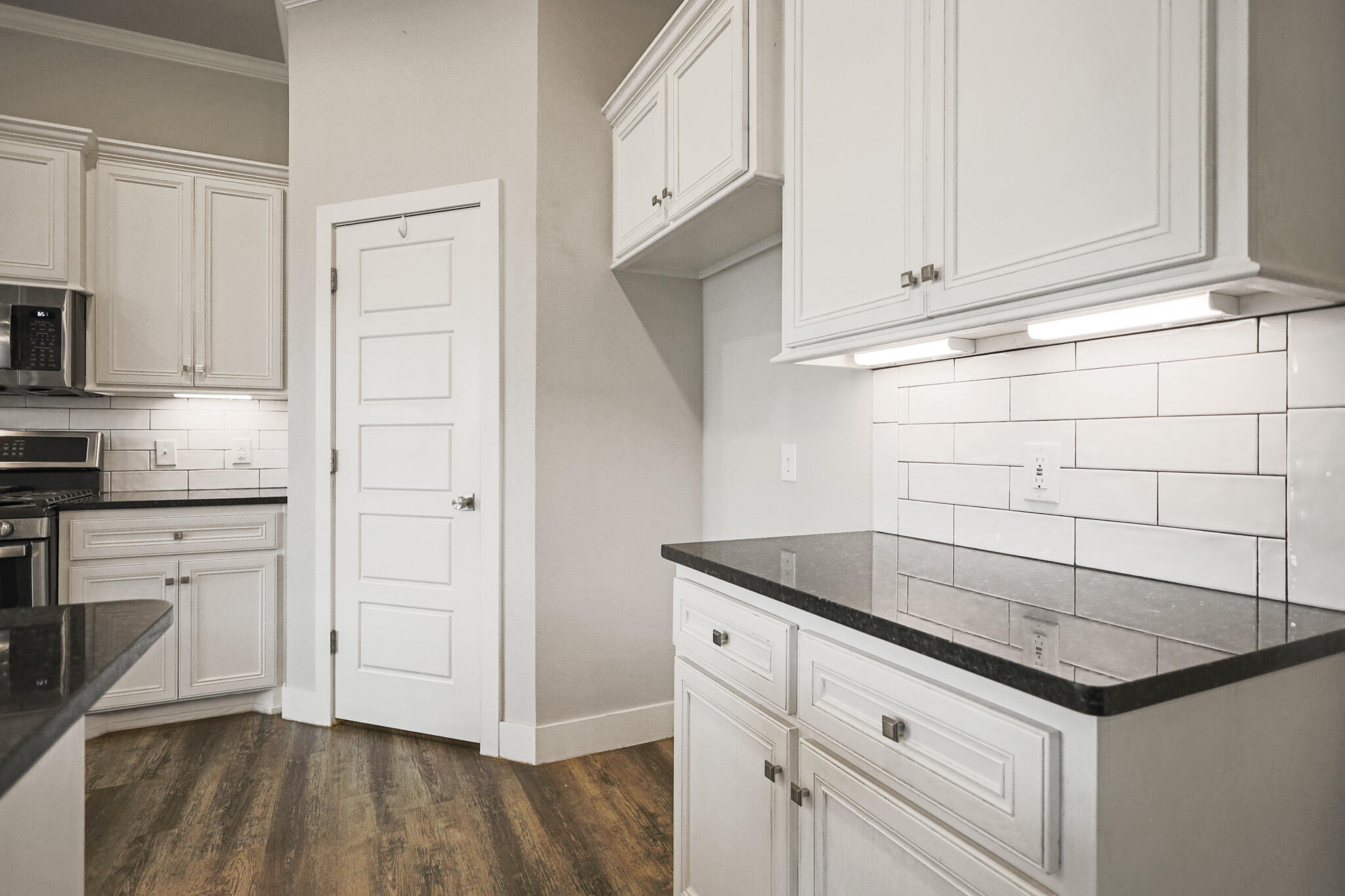 7808 58th Street Lubbock, TX 79407 - Photo 12 of 50 a kitchen with granite countertop white cabinets and white appliances
