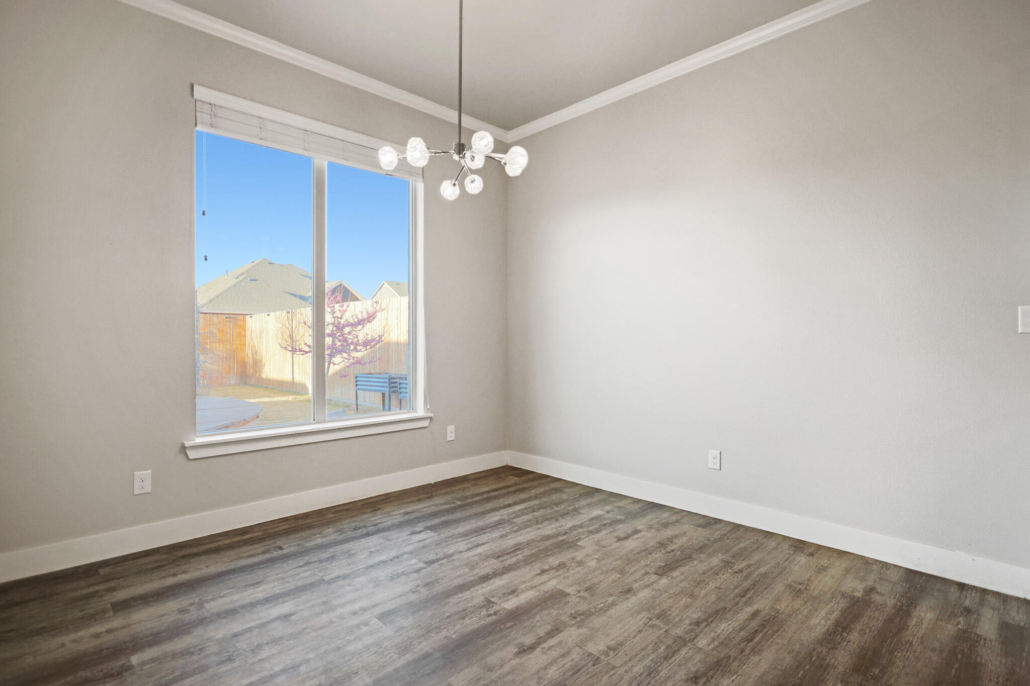 7808 58th Street Lubbock, TX 79407 - Photo 15 of 50 an empty room with chandelier fan and windows