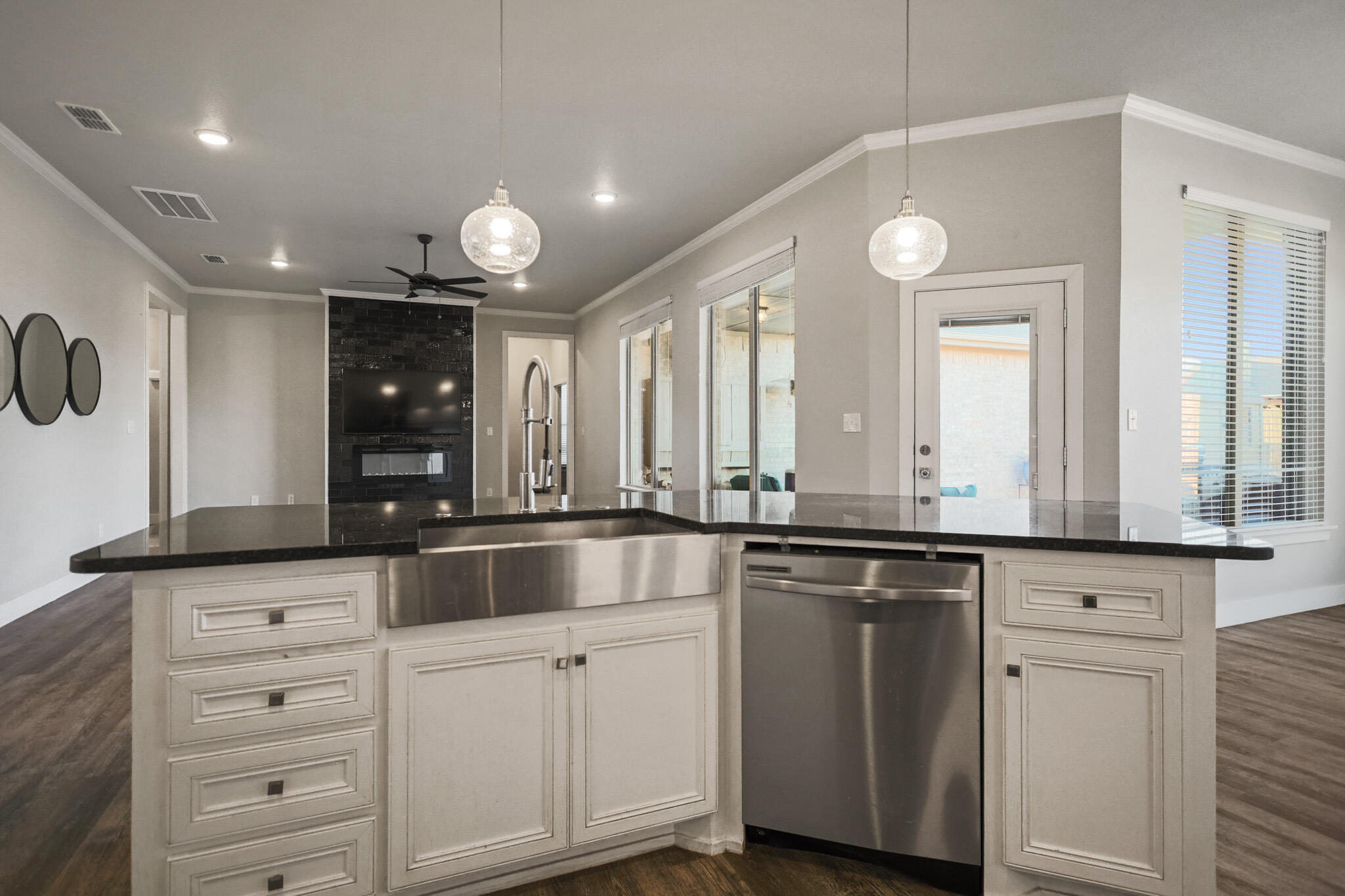 7808 58th Street Lubbock, TX 79407 - Photo 22 of 50 a large white kitchen with granite countertop a sink and dishwasher with white cabinets