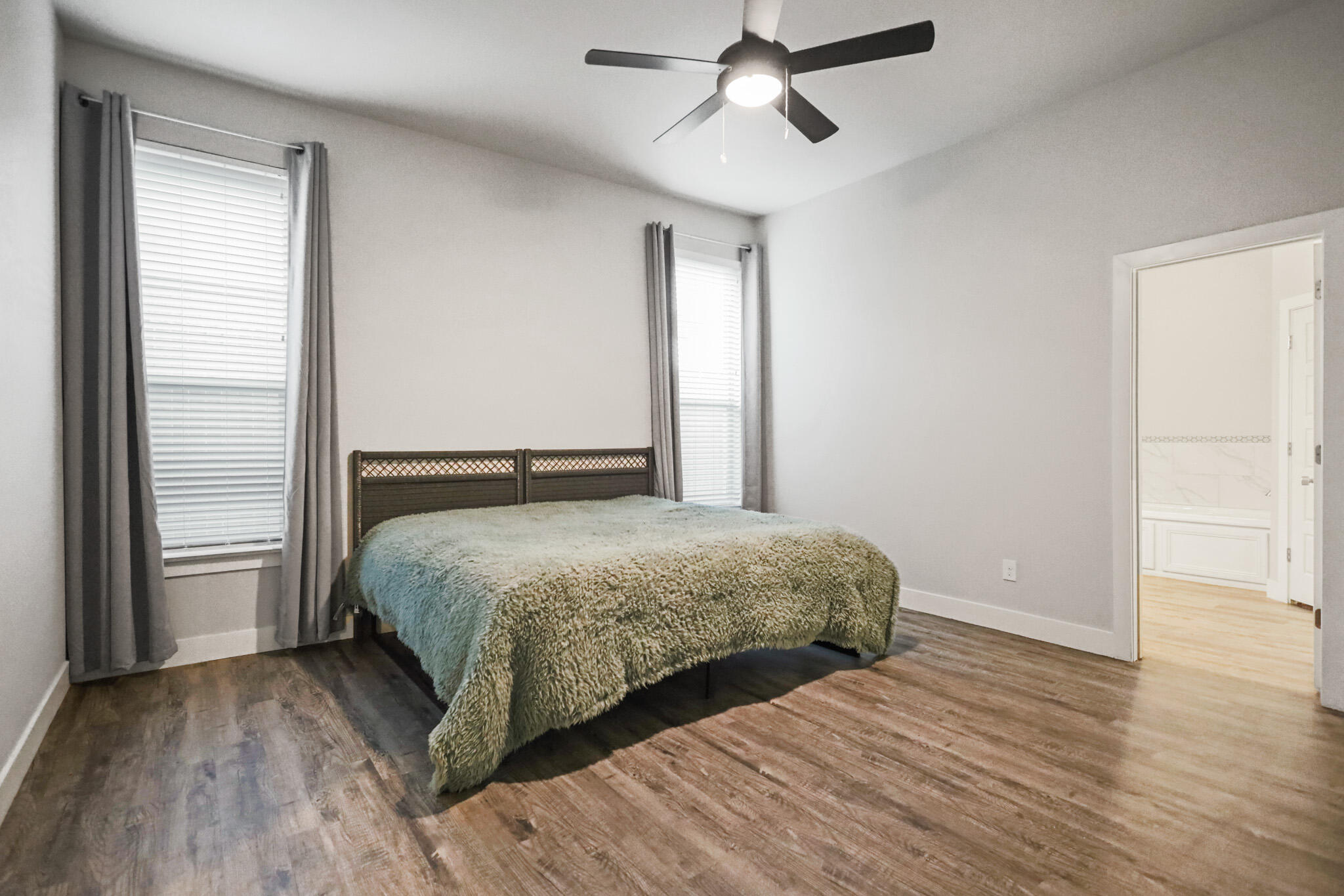 7808 58th Street Lubbock, TX 79407 - Photo 25 of 50 a bedroom with a bed and wooden floor