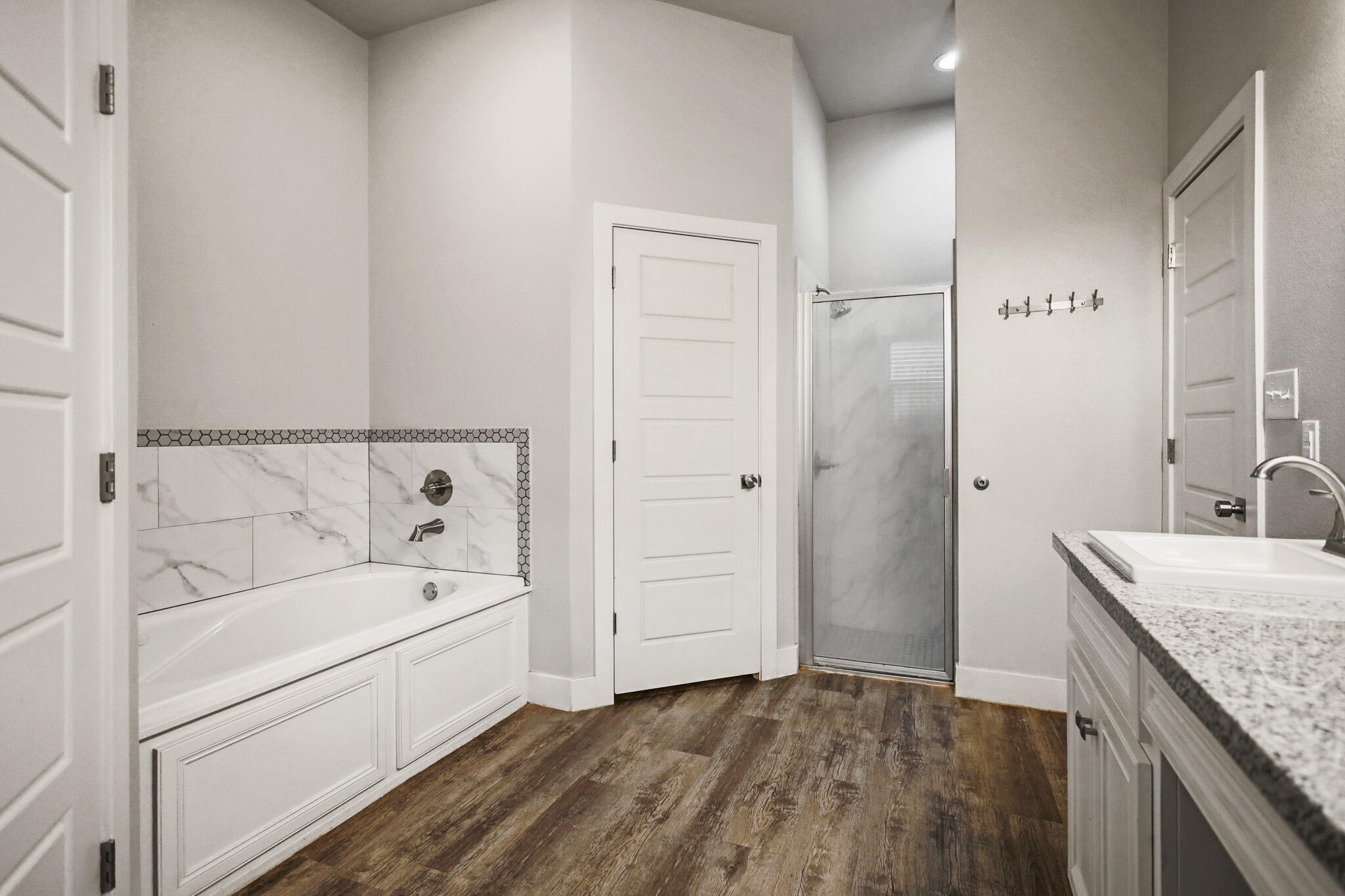 7808 58th Street Lubbock, TX 79407 - Photo 29 of 50 a bathroom with a granite countertop sink a mirror and a bathtub