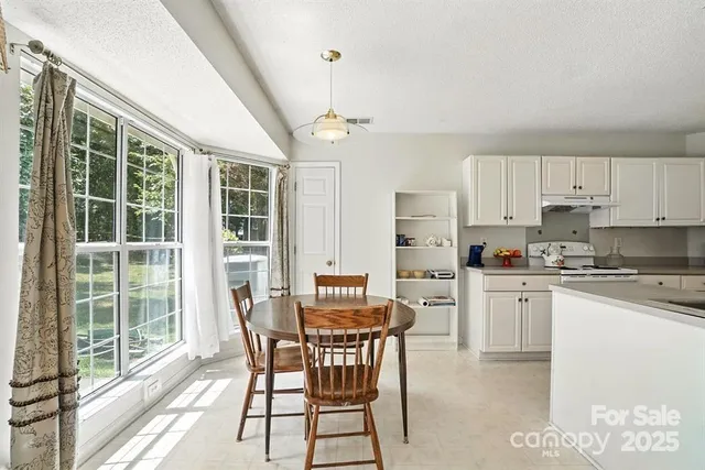 a view of a dining room with furniture large windows and wooden floor