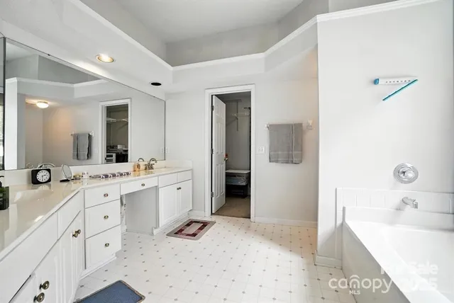 a large bathroom with a tub sink and mirror