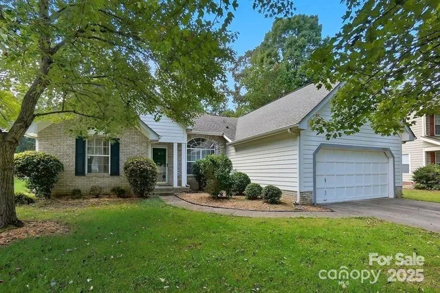 a view of a house with a yard and potted plants
