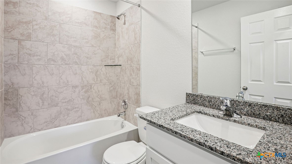 1303 Newey Circle Temple, TX 76504 - Photo 32 of 33 a bathroom with a granite countertop tub sink and toilet