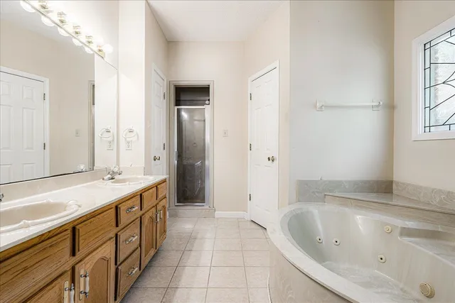 a spacious bathroom with a tub sink and mirror