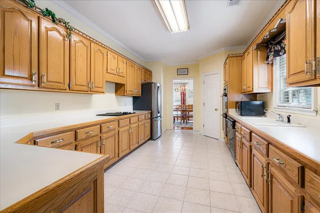 a kitchen with stainless steel appliances granite countertop a stove a sink and a microwave