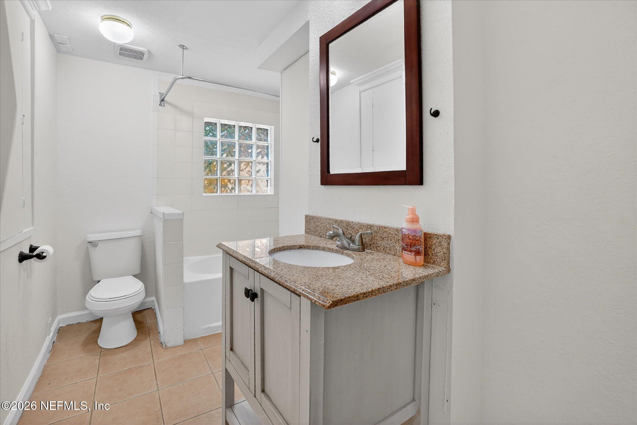 1217 Cook Street Jacksonville, FL 32205 - Photo 10 of 43 a bathroom with a granite countertop sink toilet and mirror