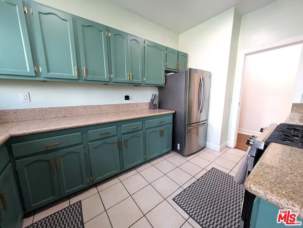 a kitchen with stainless steel appliances granite countertop a refrigerator and a cabinets