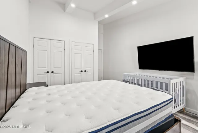a bedroom with a bed and flat screen tv