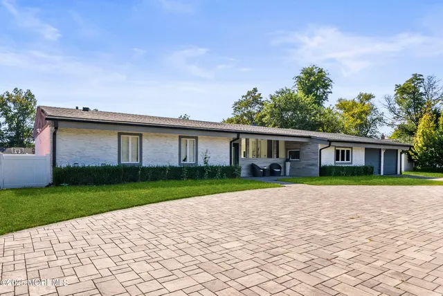 a front view of a house with a yard and trees