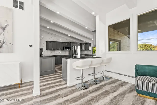 a living room with a sink and a dining table with outer view