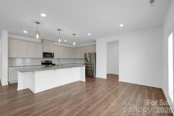 a view of kitchen with kitchen island stainless steel appliances refrigerator sink and stove