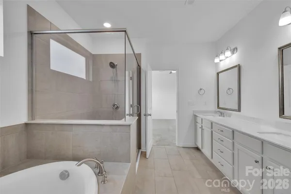 a bathroom with a tub sink and mirror