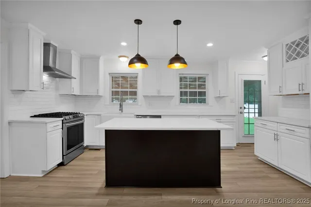 a kitchen with stainless steel appliances a stove cabinets and wooden floor