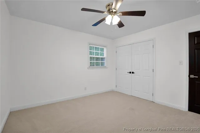 an empty room with a window and a ceiling fan